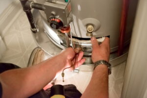 Technician working on water heater in home.
